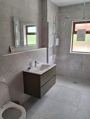 Une salle de bain moderne équipée de toilettes, d’un lavabo et d’une douche.