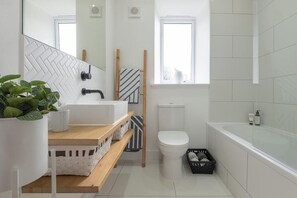 Een haardroger, handdoeken, zeep, toiletpapier