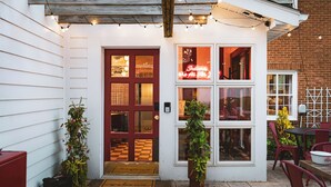 A building with a red door, multiple windows, and string lights. - Hoosier Memories! Luxury Stay, Steps from IU - Pool Table, Firepit & More (Bloomington)