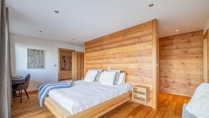 A modern bedroom with a wooden bed frame, a desk, and a chair. - Chalet La Vue (Les Crettaux - Nendaz) (Isérables)