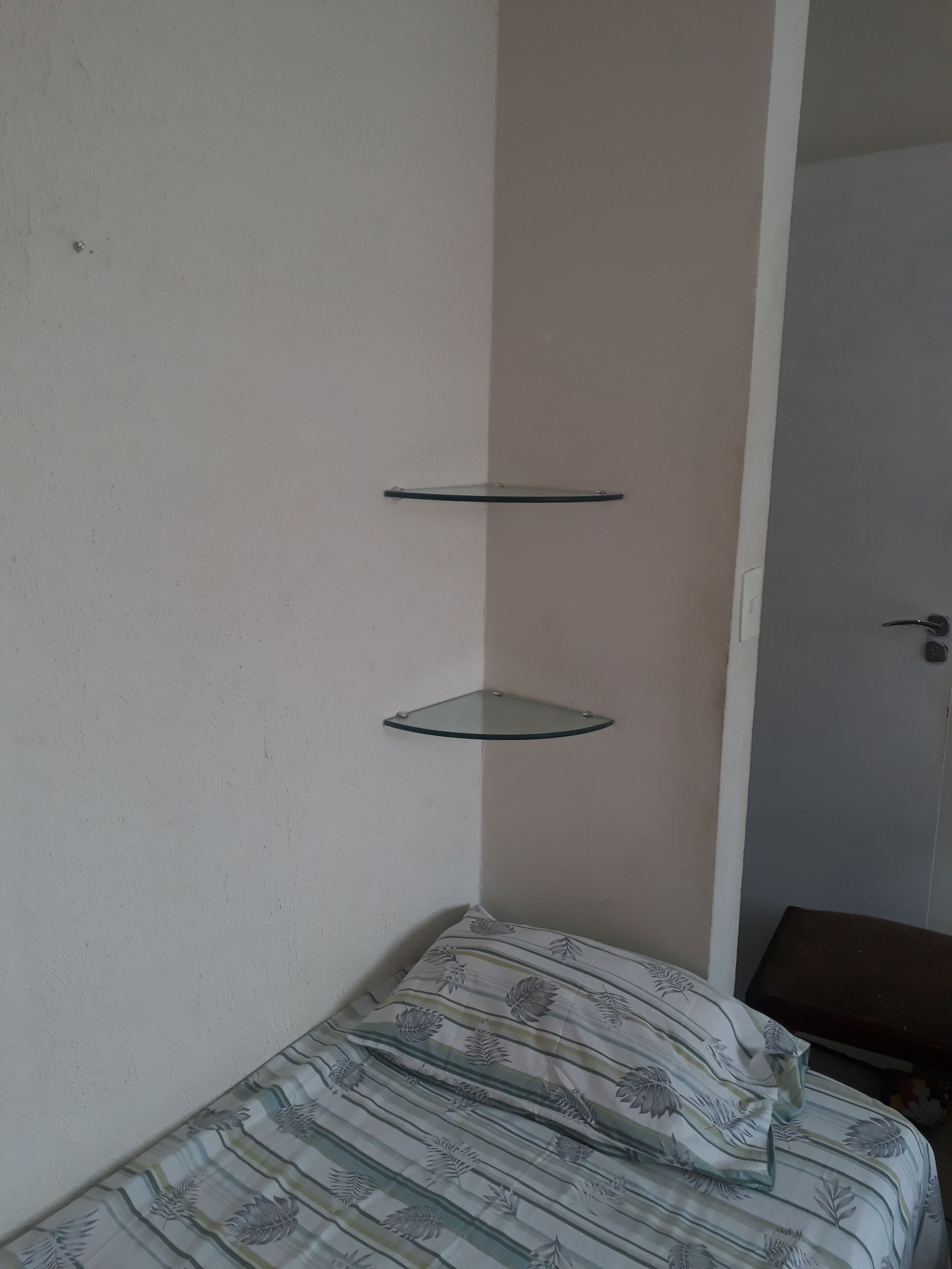 Ein Schlafzimmer mit einem Bett, einer weißen Wand und einer Tür.