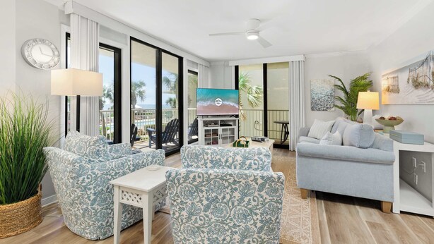 A modern living room with patterned sofas, a flat-screen TV, and a view of the ocean. - Seaside Beach & Racquet Club 5214 (Orange Beach)
