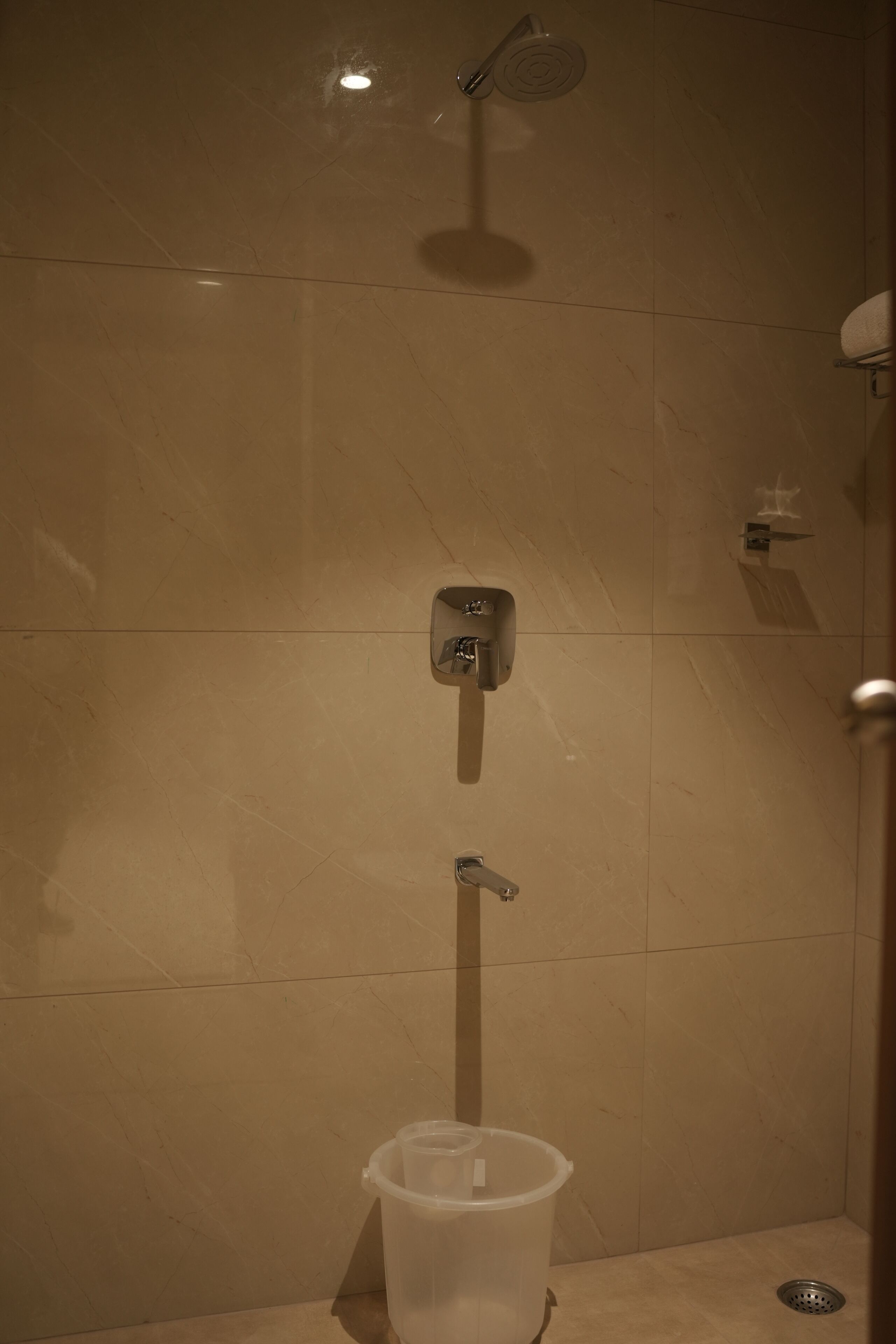 Un baño con ducha, inodoro y cubo de basura.