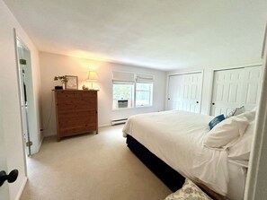 Une chambre à coucher avec un lit, une commode et une fenêtre.