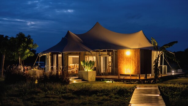 A tent-style accommodation with a wooden deck and a pathway leading to the entrance. - The Alampara resort (Cheyyur)