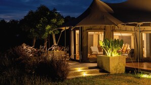 A tented outdoor area with a seating arrangement and a large planter. - The Alampara resort (Cheyyur)