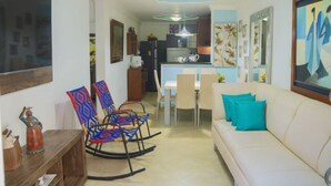 A living room with a sofa, colorful chairs, a dining table, and a kitchen in the background. - Entire rented housing in Cartagena de Indias, Colombia (Cartagena de Indias)