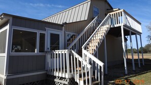 A two-story house with a covered porch and a staircase. - Mason Ranch Guest House (Mason)