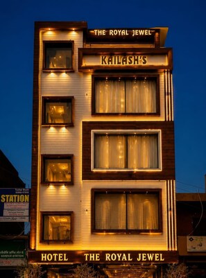Un hôtel appelé « The Royal Jewel », doté d’une enseigne lumineuse et de nombreuses fenêtres.