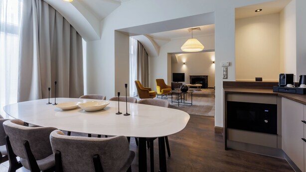 A modern hotel room with a dining area, kitchen, and living space. - Apartments Kozmo Residences Budapest (Budapest)