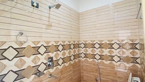 A small, tiled bathroom with a sink, toilet, and shower. - Hotel RISHI (Bhatwari)