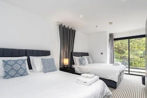 Ett hotellrum med två sängar, ett stort fönster med utsikt och en balkong.