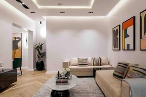Relax in this stylish living room with a round coffee table, comfortable sofa, and lush greenery.