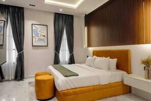 Relax in a serene bedroom with a large bed, bedside table, and abstract art.