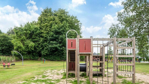 A playground with a climbing structure and swings. - 2 Person Holiday Park Home in Jelling (Jelling)