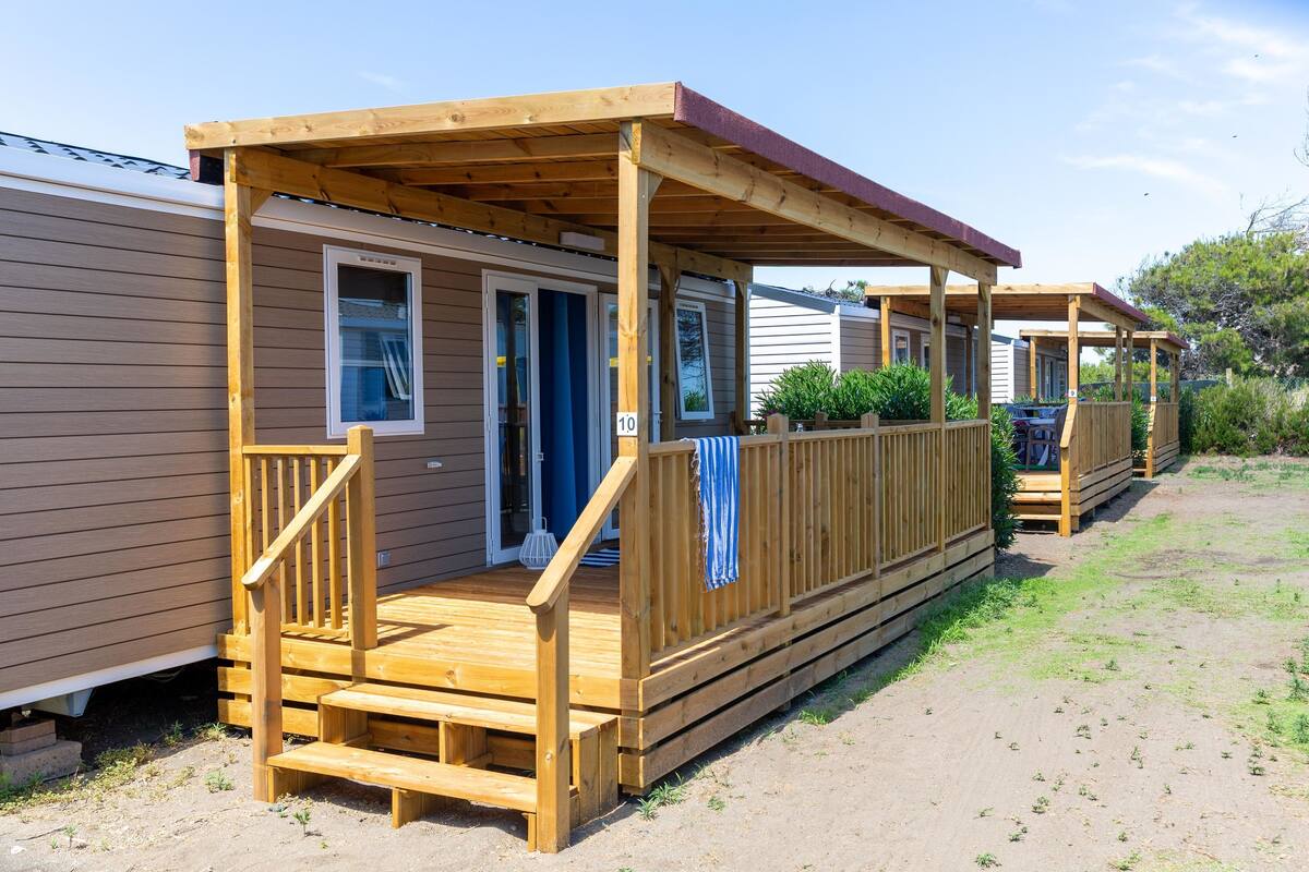 Une rangée de maisons mobiles dotées de terrasses en bois et de vérandas.