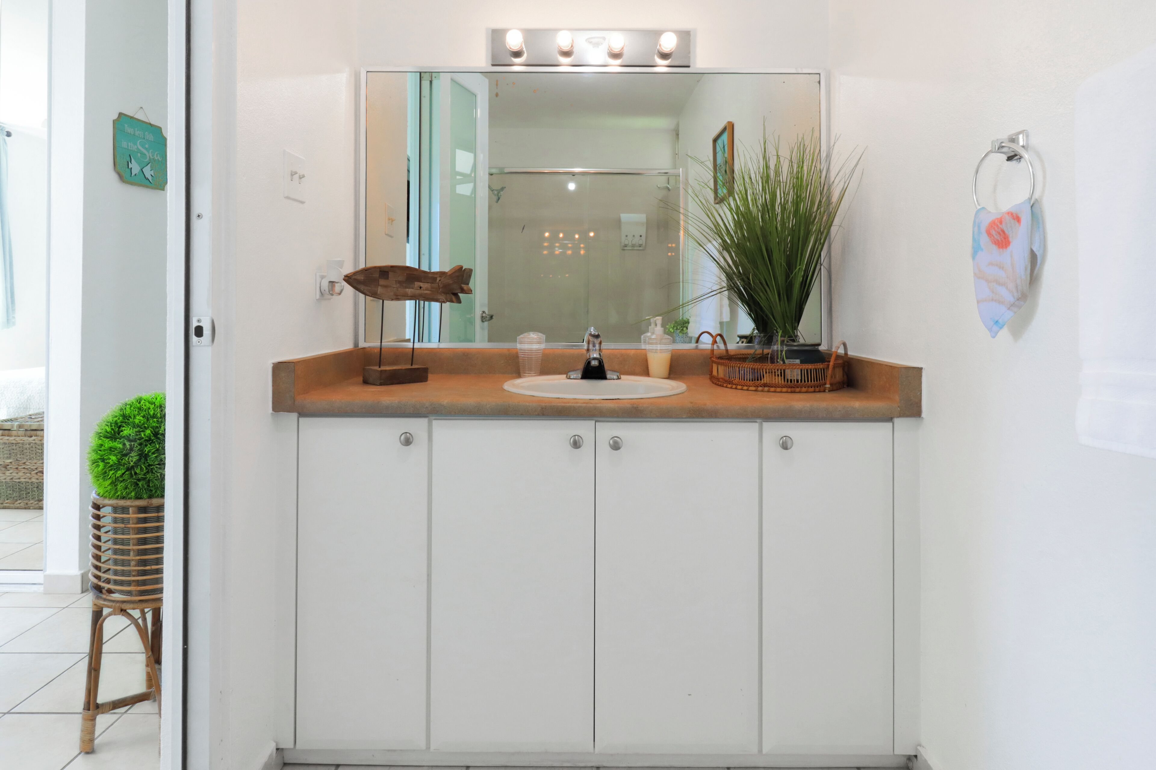 A bathroom vanity with a mirror, sink, and cabinets.