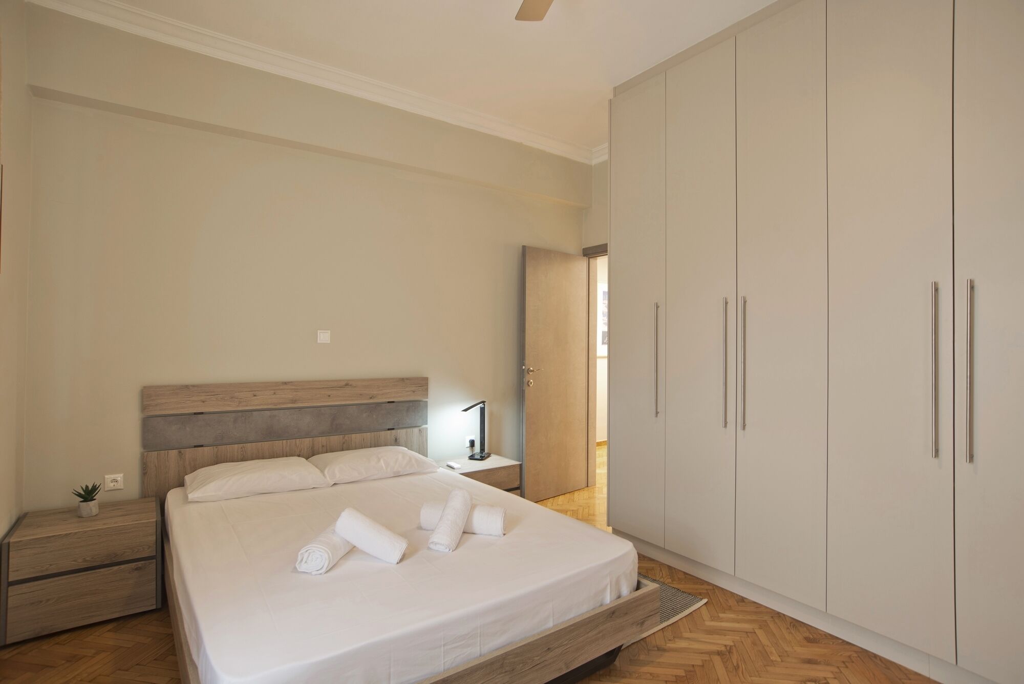 Een slaapkamer met een bed, nachtkastje en kledingkast.