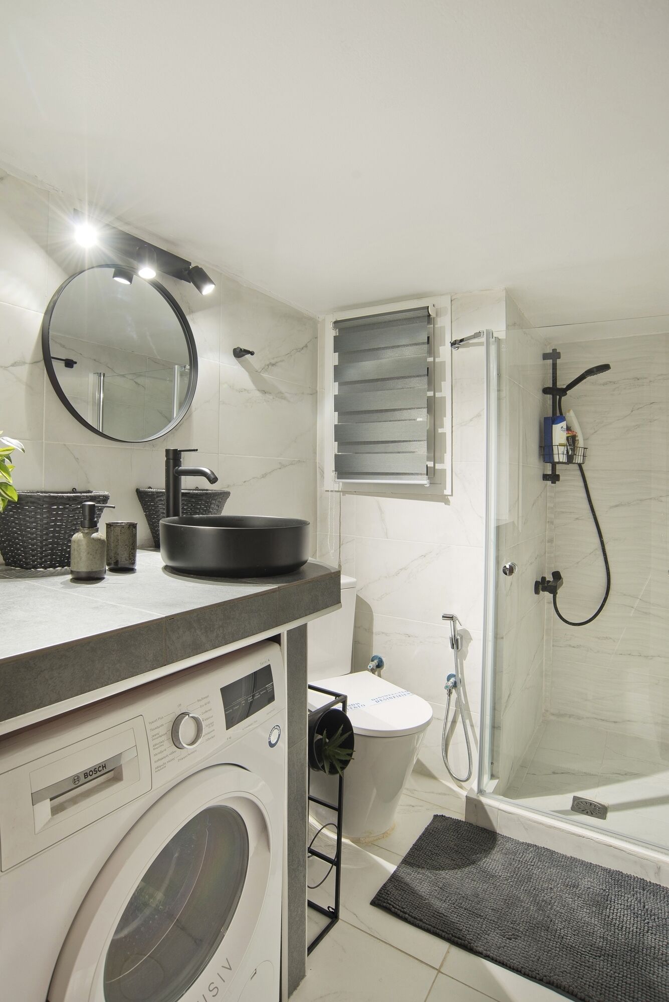 A modern bathroom with a sink, mirror, and shower.