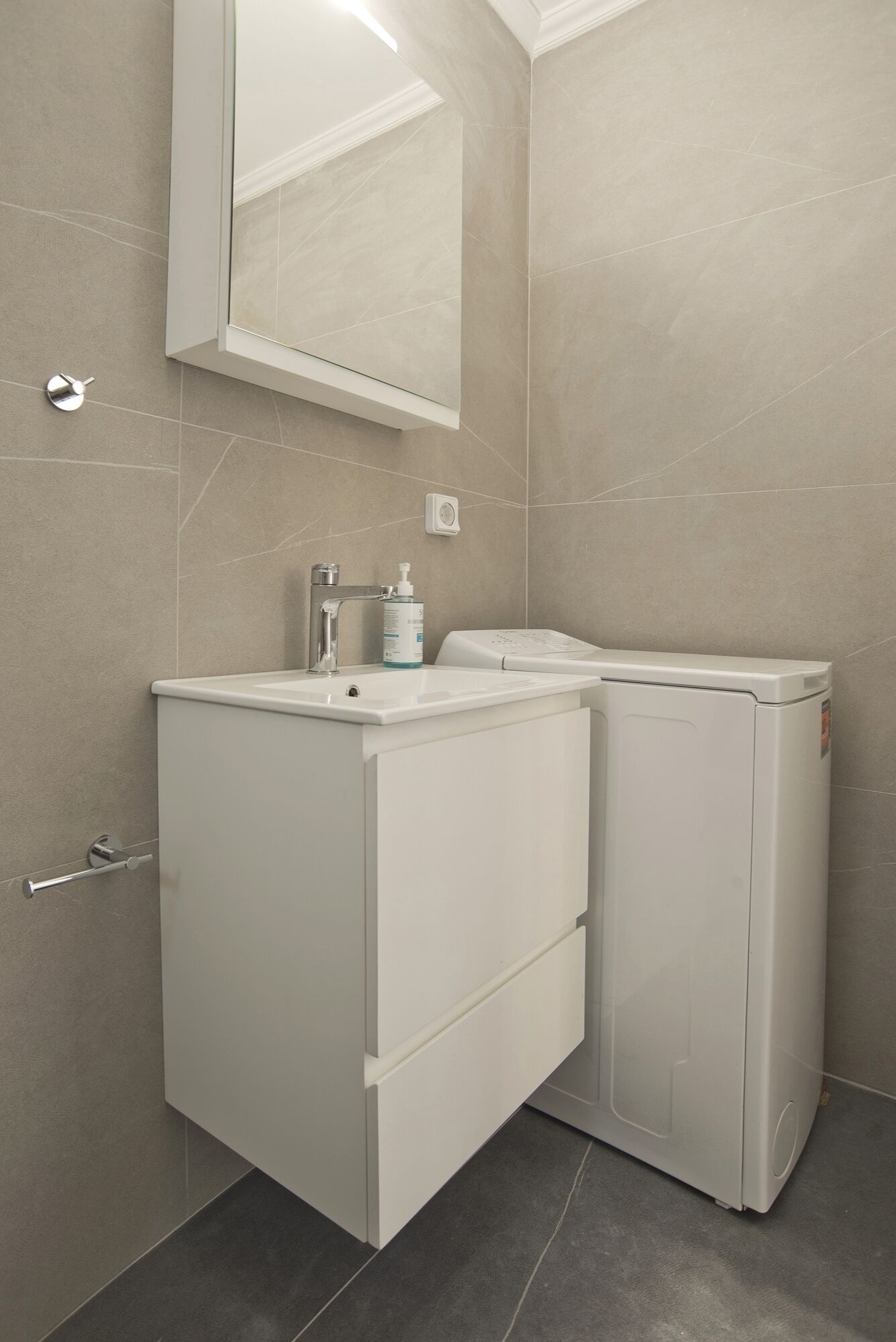 A compact bathroom with a sink, mirror, and two white cabinets.