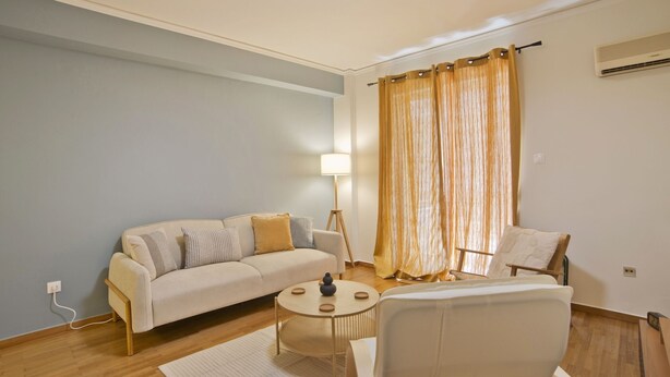 Una sala de estar moderna con un sofá, un sillón y una mesita de centro.