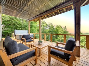 A wooden deck with outdoor furniture, a grill, and a view of a forested area. - Mountain Views, Hot Tub, Fire Pit & Top Location in Boone, NC (Watauga County)