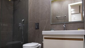 A modern bathroom with a glass-enclosed shower, a white toilet, and a vanity with a mirror. - Welcome Northern Avenue Apartments (Yerevan)
