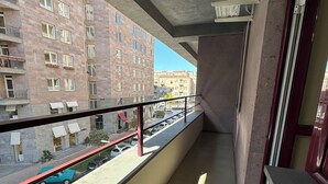 A balcony with a view of a street and buildings. - Welcome Northern Avenue Apartments (Yerevan)
