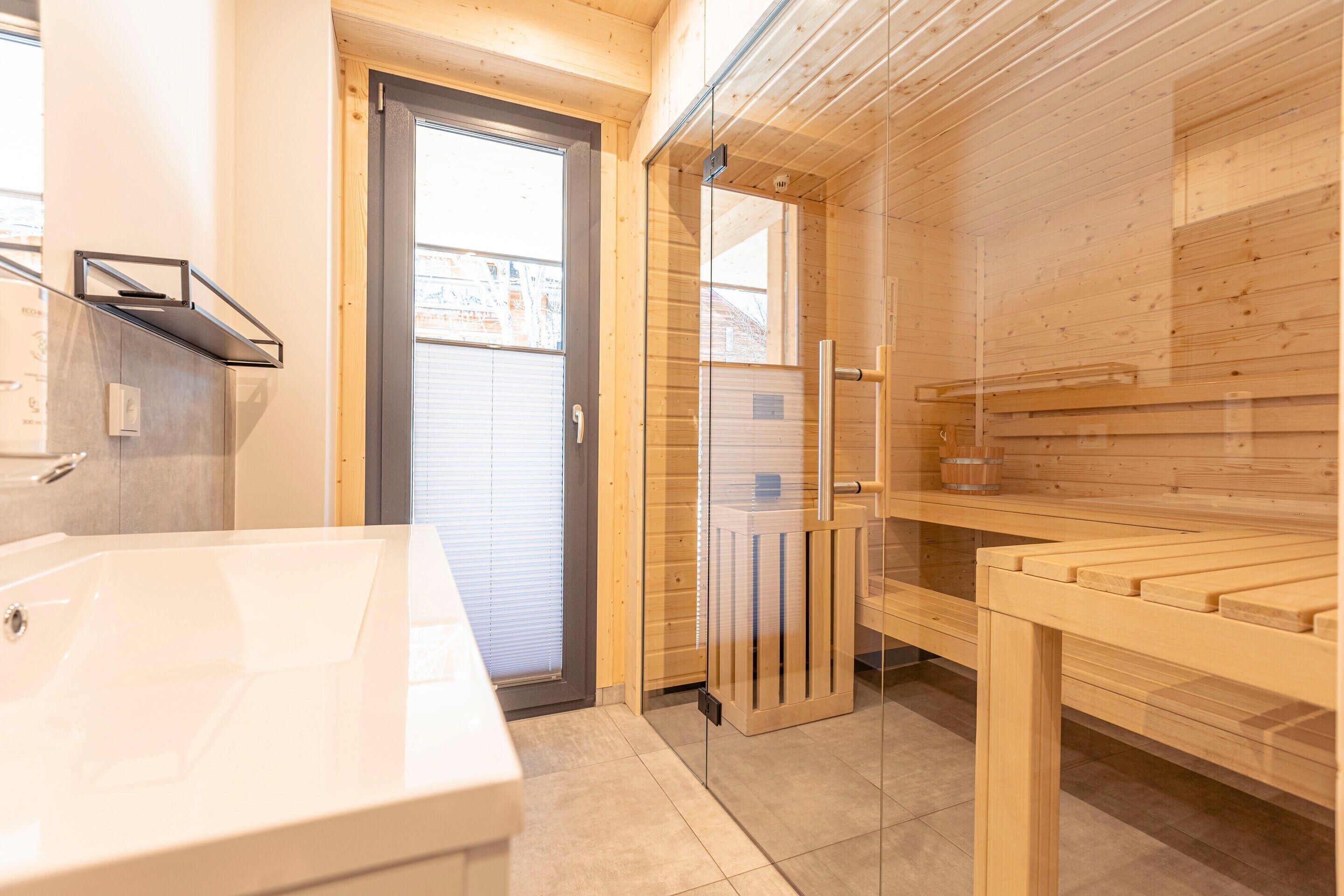 Un baño moderno con una bañera blanca grande, cabina de ducha con paredes de vidrio y paneles de madera.