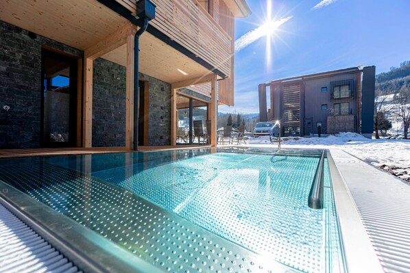 A modern building with a pool, wooden deck, and a view of the mountains. - Cosy Apartment With Sauna (Sankt Georgen am Kreischberg)