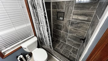 Regadera, tina de hidromasaje, secadora de cabello, toallas