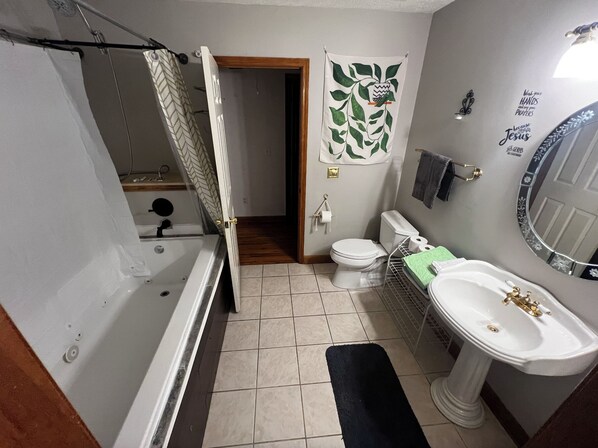 A bathroom with a bathtub, toilet, sink, and a shower curtain.