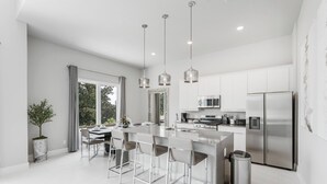 A modern kitchen with a central island, stainless steel appliances, and pendant lighting. - 226 Spectrum new Loft 12 guests 5BDRS 15min Disney (Kissimmee)