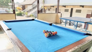 Une table de billard recouverte d’un drap bleu et sur laquelle les billes sont disposées en forme de triangle.