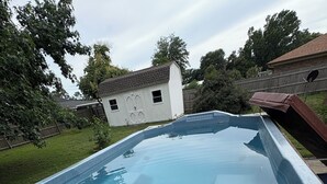 A hot tub with a control panel, surrounded by a wooden deck and a grassy yard. - Your Perfect Perdido Key Getaway (Pensacola)