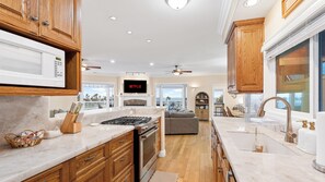 A modern kitchen with wooden cabinets, a built-in microwave, and a large window. - Oceanview home walking distance to beach, pier & short drive to downtown Ventura (Ventura)