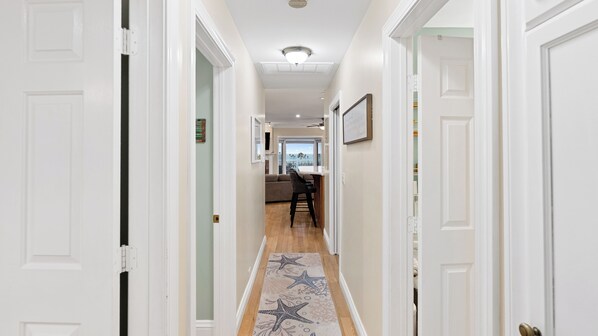 A hallway with white doors, a wooden floor, and a starfish-patterned rug. - Oceanview home walking distance to beach, pier & short drive to downtown Ventura (Ventura)
