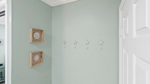 Et værelse med en lysegrøn væg, en trædør og et hvidt loft.