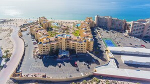 Un resort con varias construcciones, una zona de piscina y una playa.