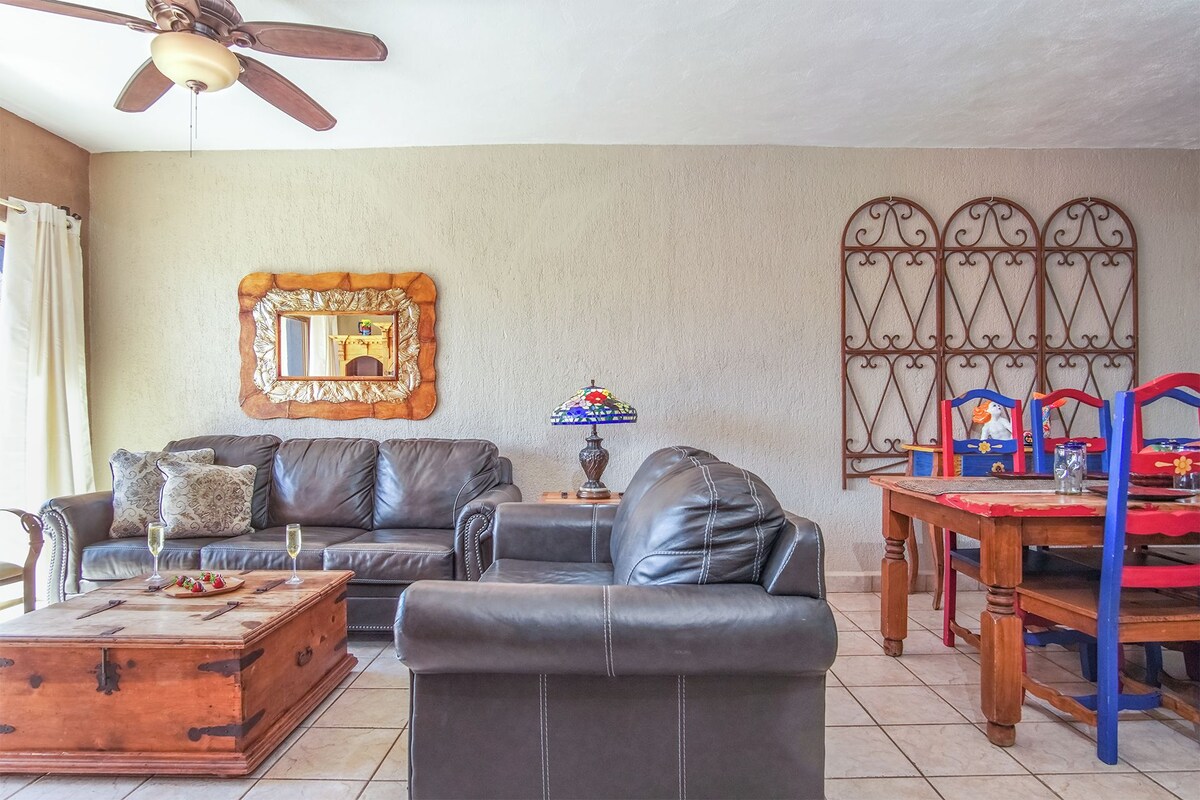 A living room with a sofa, coffee table, and a dining table with chairs.