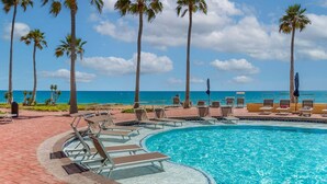 A pool area with lounge chairs, palm trees, and a view of the ocean. - Princesa De Penasco II (Puerto Peñasco)