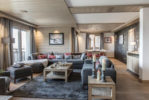 A modern living room with a sofa set, a coffee table, and a fireplace.