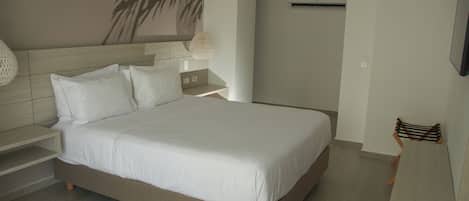 Een moderne slaapkamer met een groot bed, een nachtkastje, een wandlamp en een plafondventilator.