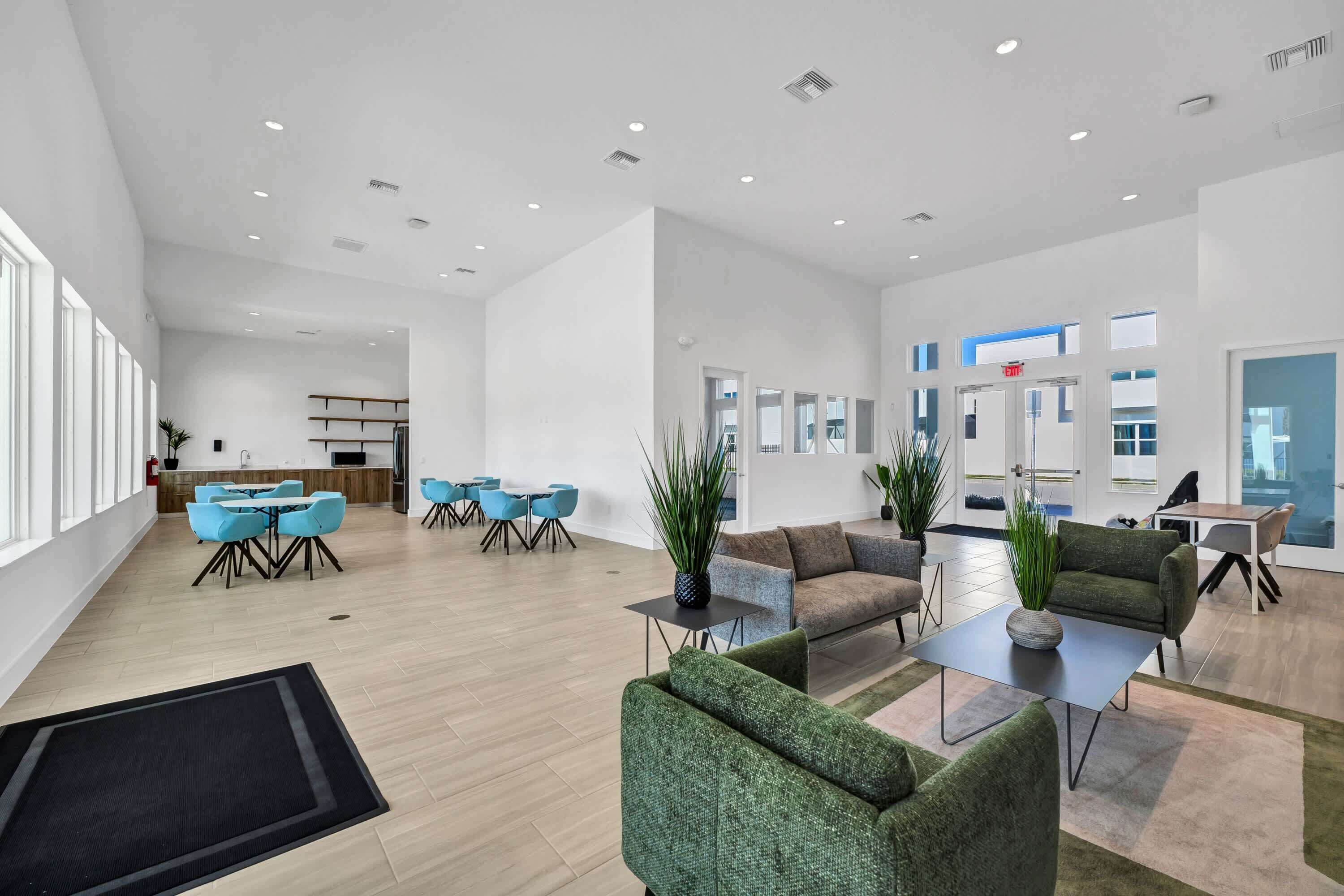 Un hall d’hôtel spacieux et moderne, comprenant un espace repas, des coins salon et un comptoir d’accueil.