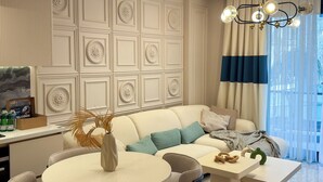 Una sala de estar moderna con un sofá, una mesa de comedor redonda y sillas.