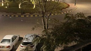 A nighttime view of a residential area with a roundabout, parked cars, and illuminated street lamps. -  2-bedroom apartment with AC, WiFi in Casa Beverly Hills Compound-sheikh zayed (Giza Governorate)