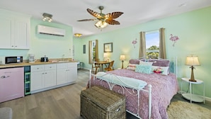 A bedroom with a bed, bedside tables, a desk, and a window. - Cozy Studio Retreat Above Cedar Key Island Bakery (Cedar Key)