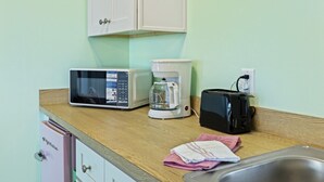 A kitchenette with a microwave, coffee maker, toaster, and a sink. - Cozy Studio Retreat Above Cedar Key Island Bakery (Cedar Key)