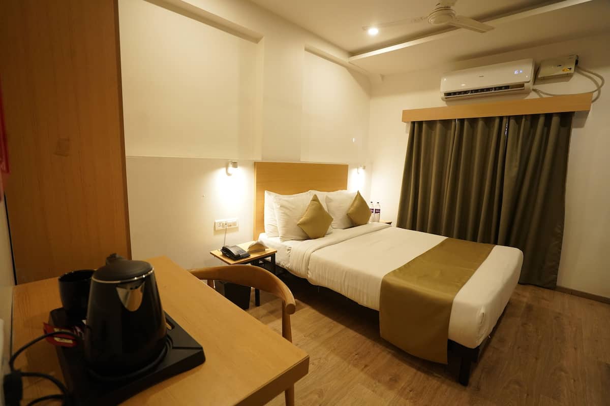 A hotel room with a bed, bedside table, and a coffee maker.