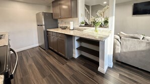 Una cocina moderna con armarios de madera oscura, un refrigerador de acero inoxidable y una encimera de granito.